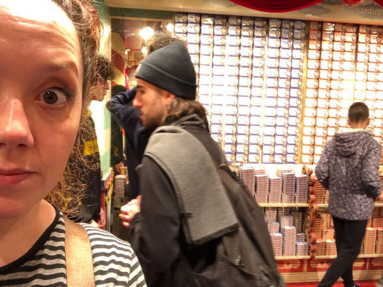 Standing in front of rows and rows of canned fish.