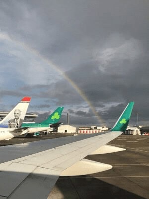 Aer Lingus planes on the tarmac. A rainbow is visible over the wing.