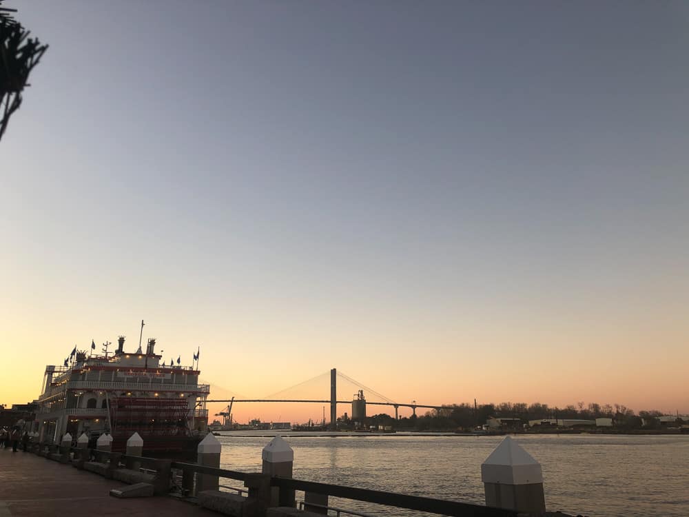 Historic Downtown Savannah on the riverfront with a riverboat at sunset