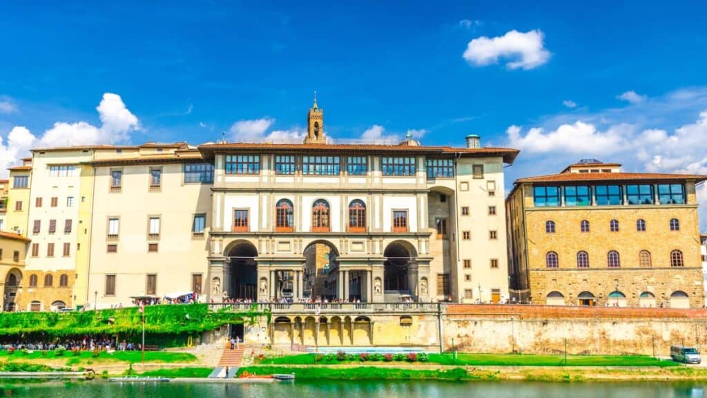 Museo Galileo museum, Gallerie degli Uffizi gallery and buildings on embankment promenade of Arno river in historical centre of Florence city, blue sky white clouds background, Tuscany, Italy