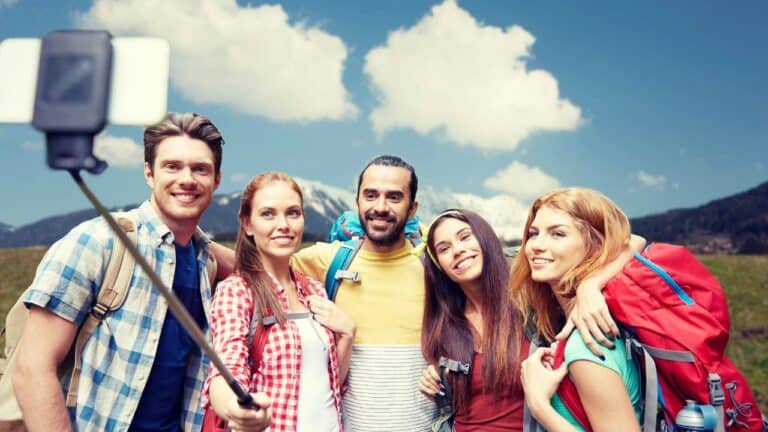 Group of travelers taking a photo with a selfie stick