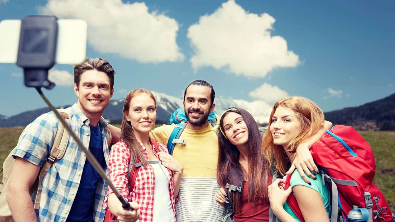 Group of travelers taking a photo with a selfie stick