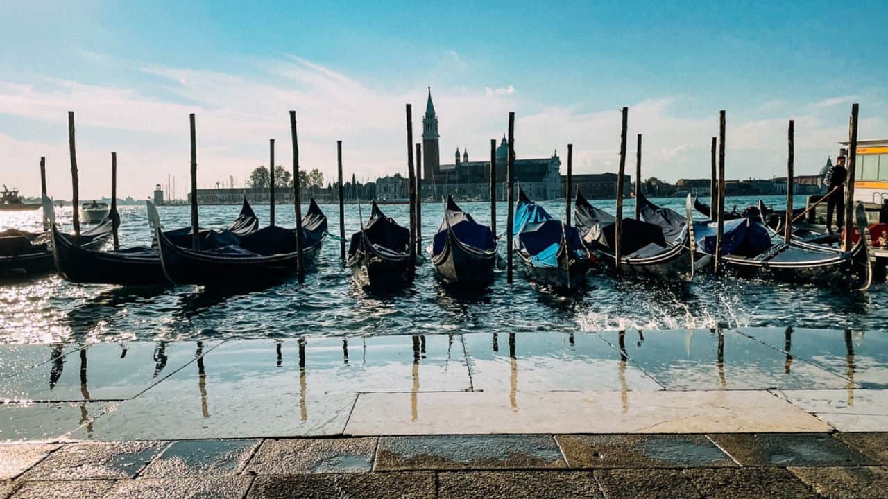Gondolas in Venice lined up in a flooded canal.