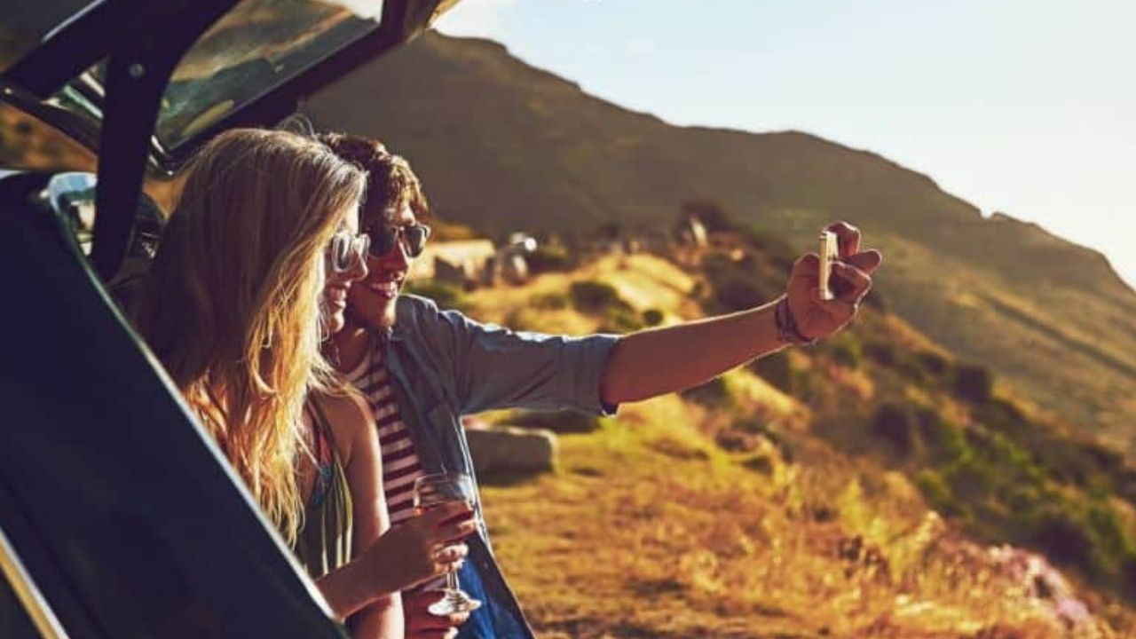 A couple taking selfie while on a road trip in the fall.