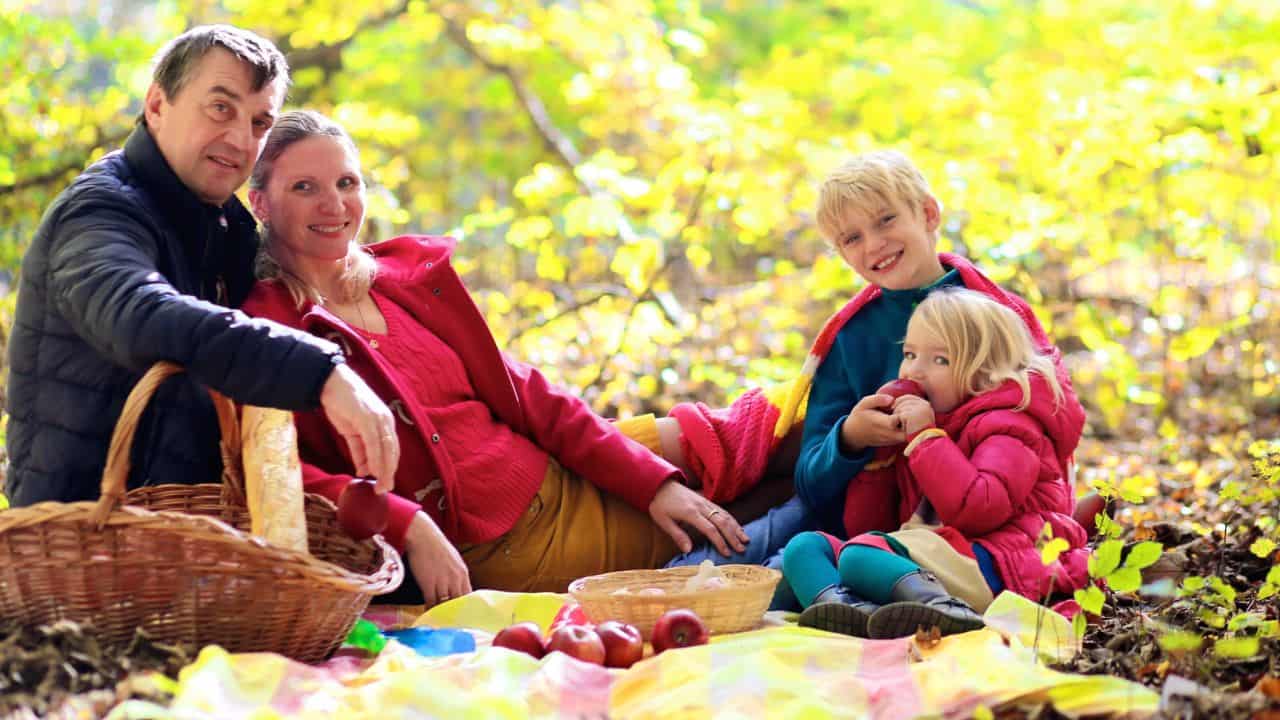 Family picnicking in the park or forest. Autumn.