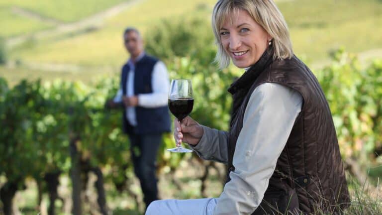 Couple with a glass of wine in the vineyard