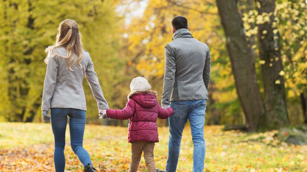 Happy family walking at autumn park