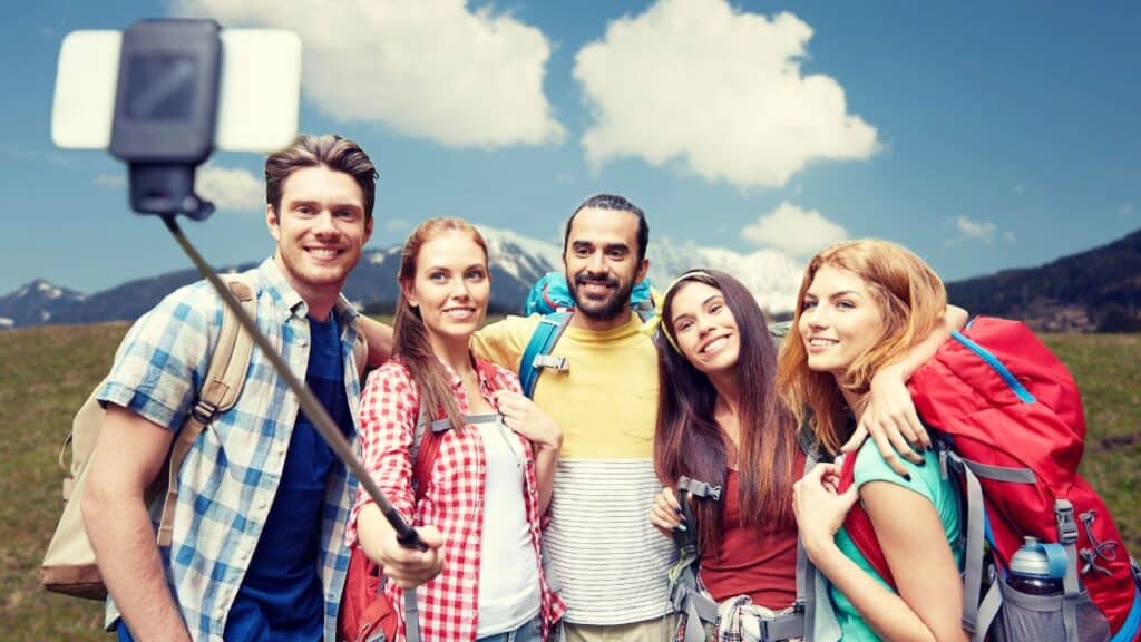 Friends with backpack taking selfie by smartphone