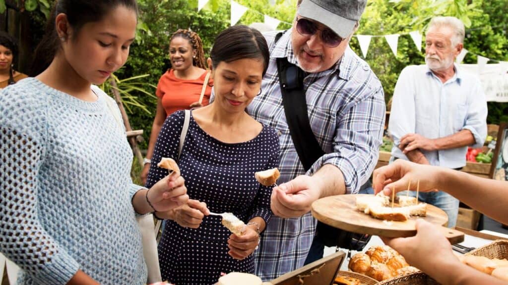 People enjoying a food festival eating food samples.