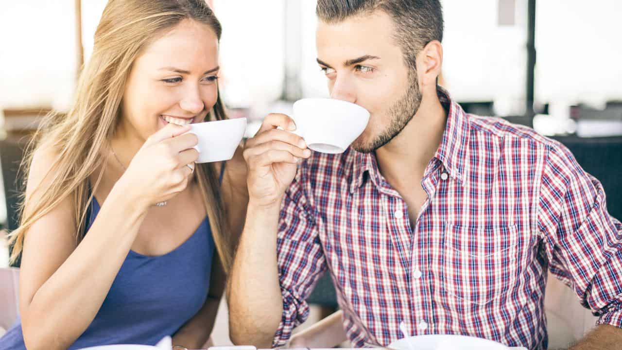 Couple making breakfast at home drinking coffee