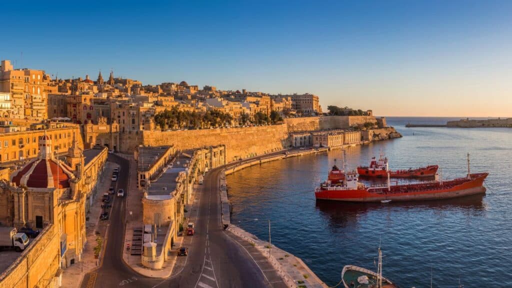 Valletta, Malta - Skyline view of Valletta and the Grand Harbor with beautiful sunrise, ships and clear blue sky