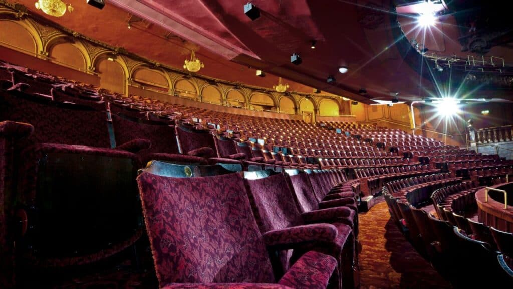 Empty red velvet seats in a theatre