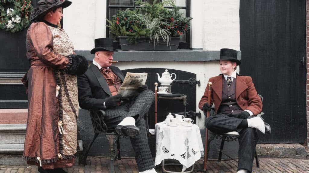 Actors dressed in Victorian costumes performing from A Christmas Carol by Charles Dickens