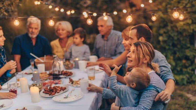 Multi-generational family around a table outside in the backyard.