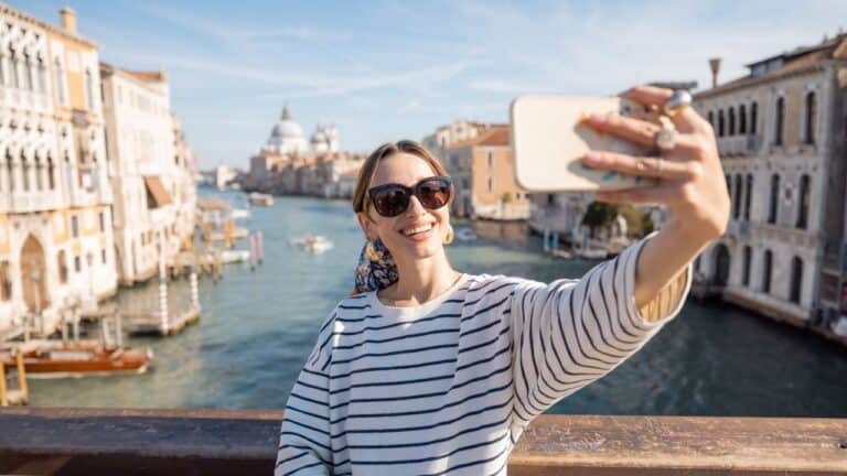 woman talking a selfie on the grand canal in Venice, Italy